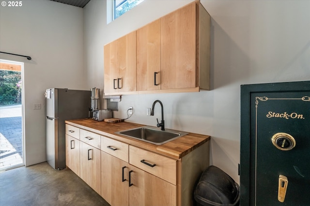 2345 Deady St, Port Orford, OR 97465 - kitchen with finished concrete floors, a high ceiling, light brown cabinetry, wood counters, and a sink