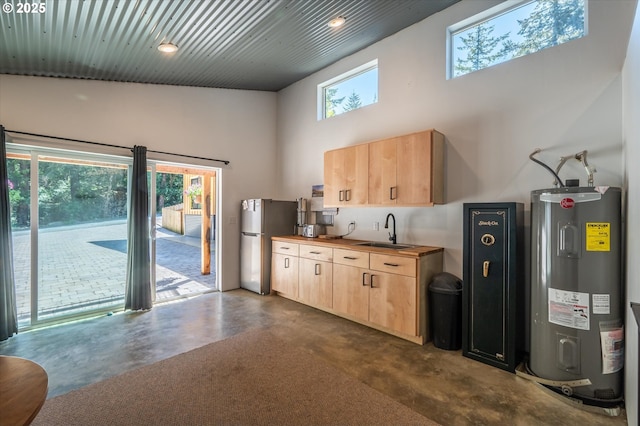2345 Deady St, Port Orford, OR 97465 - kitchen featuring a sink, water heater, light brown cabinetry, and freestanding refrigerator
