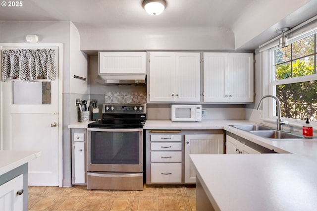 3374 Pioneer Dr, Salem, OR 97302 - kitchen featuring electric stove, white microwave, range hood, light countertops, and white cabinetry