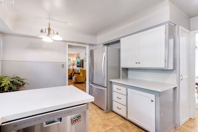 3374 Pioneer Dr, Salem, OR 97302 - kitchen featuring appliances with stainless steel finishes, light countertops, white cabinetry, decorative light fixtures, and a chandelier