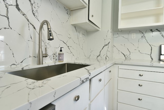 4820 SE Haig St, Portland, OR 97206 - kitchen featuring a sink, decorative backsplash, white cabinetry, and light stone counters