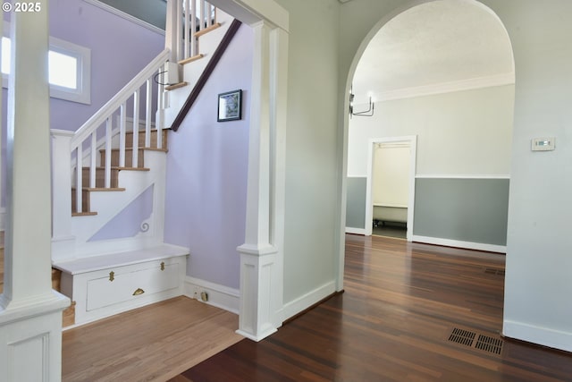 4820 SE Haig St, Portland, OR 97206 - stairs featuring wood finished floors, arched walkways, crown molding, and baseboards