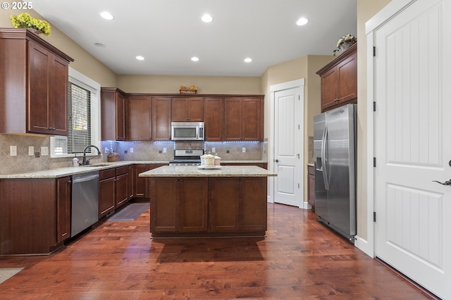 27387 SW Copper Creek Loop, Wilsonville, OR 97070 - kitchen with appliances with stainless steel finishes, a center island, dark wood-style flooring, tasteful backsplash, and recessed lighting