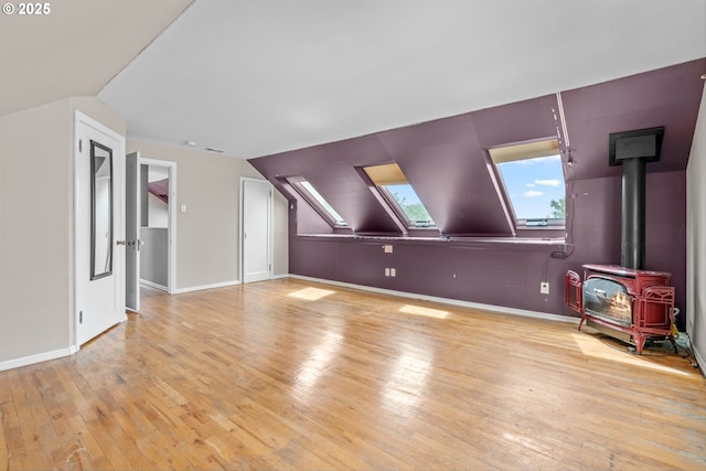 4715 N Willamette Blvd, Portland, OR 97203 - additional living space featuring light wood finished floors, lofted ceiling, a wood stove, and a skylight
