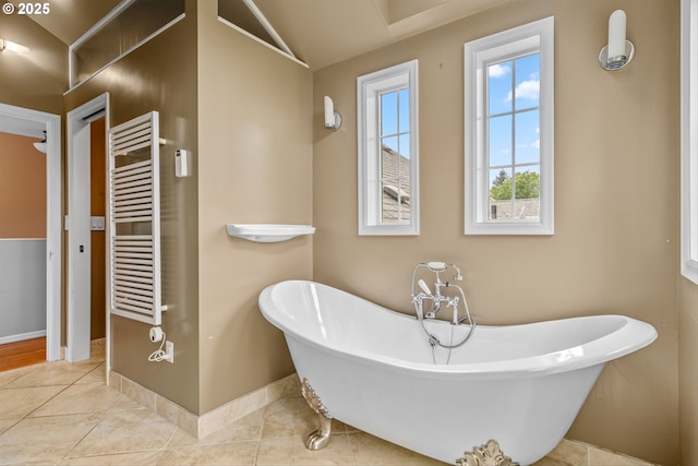 4715 N Willamette Blvd, Portland, OR 97203 - bathroom with radiator heating unit, a towel warmer, a soaking tub, vaulted ceiling, and tile patterned floors