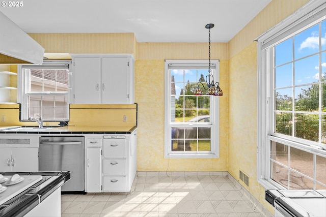 4715 N Willamette Blvd, Portland, OR 97203 - kitchen with tile counters, stainless steel dishwasher, plenty of natural light, and wallpapered walls