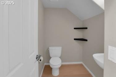 bathroom featuring toilet and lofted ceiling