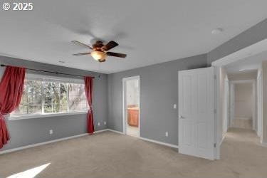 unfurnished bedroom with light carpet, connected bathroom, and ceiling fan