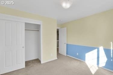 unfurnished bedroom featuring a closet and light carpet