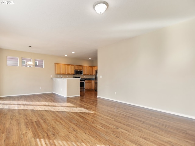 unfurnished living room featuring light wood-type flooring and baseboards