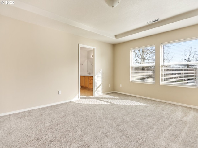 empty room featuring baseboards, visible vents, and light colored carpet