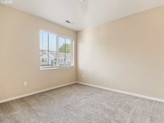 carpeted empty room featuring baseboards and visible vents