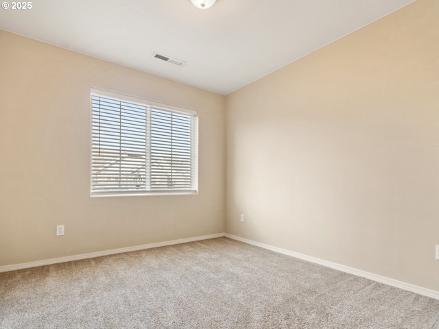 carpeted spare room with visible vents and baseboards