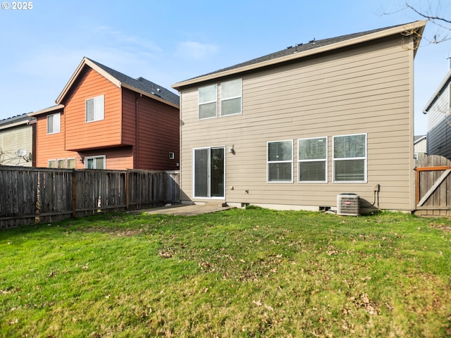 rear view of house with a fenced backyard, a lawn, and a patio