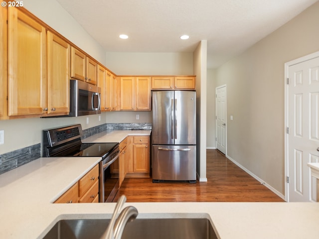 kitchen with light countertops, appliances with stainless steel finishes, light brown cabinets, and recessed lighting