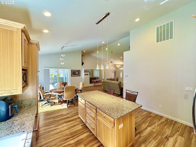 kitchen with lofted ceiling, light brown cabinets, open floor plan, light wood-style flooring, and recessed lighting