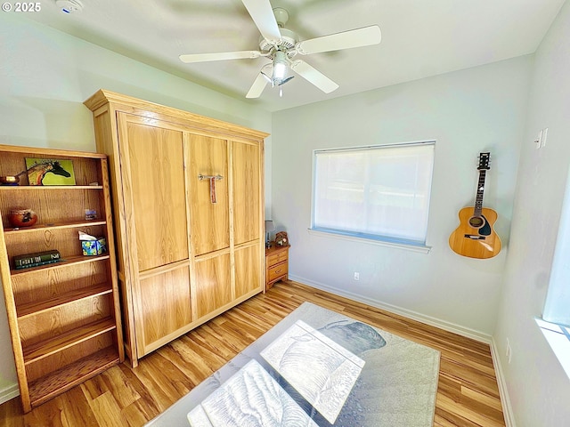 bedroom featuring light wood-style floors, baseboards, and a ceiling fan