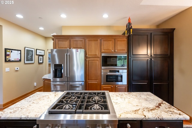 6065 Cherry Heights Rd, The Dalles, OR 97058 - kitchen with appliances with stainless steel finishes, light stone countertops, recessed lighting, a kitchen island, and baseboards