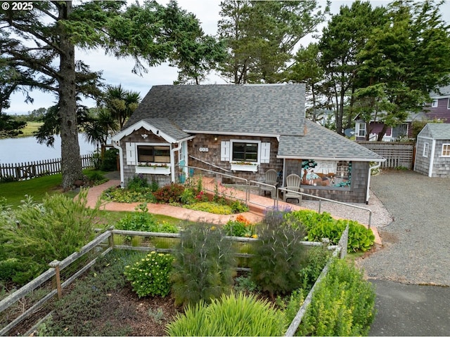 604 15th Ave, Seaside, OR 97138 - view of front of home featuring a shingled roof, a water view, and an outdoor structure