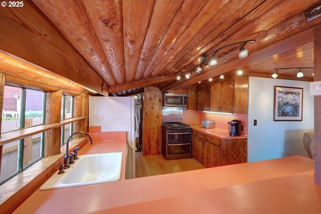 604 15th Ave, Seaside, OR 97138 - kitchen featuring stainless steel appliances, light wood-style floors, brown cabinetry, rail lighting, and wood ceiling
