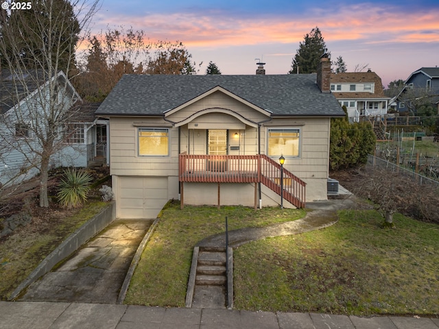 bungalow-style home with a garage and a lawn