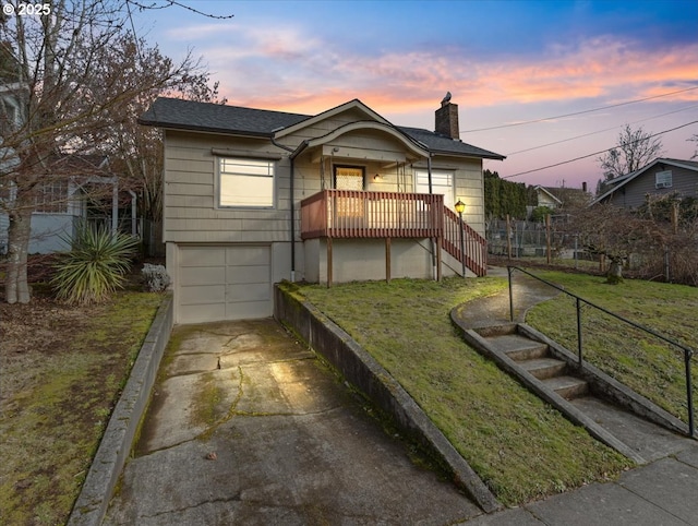 bungalow-style house featuring a garage and a yard