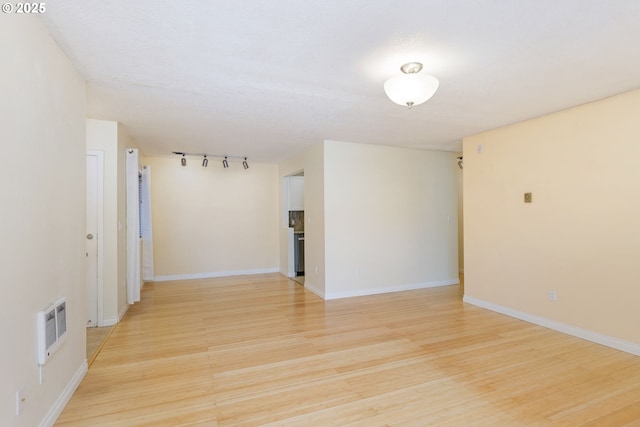 125 Oswego, Lake Oswego, OR 97035 - empty room featuring light wood-style flooring, heating unit, baseboards, and track lighting
