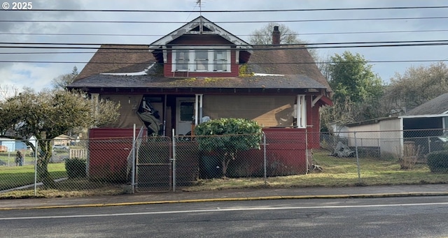 bungalow with a fenced front yard, a porch, and a shingled roof