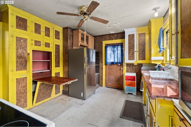 721 Columbia Blvd, Saint Helens, OR 97051 - kitchen featuring freestanding refrigerator, ceiling fan, wooden walls, light floors, and glass insert cabinets