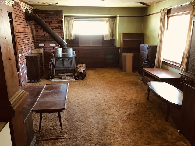 living area featuring a wood stove and carpet