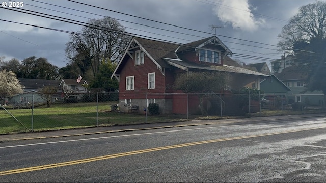 view of front facade featuring a front yard and fence