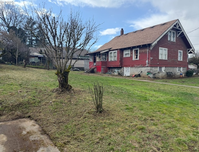 view of side of home with a shingled roof, a lawn, fence, and a chimney