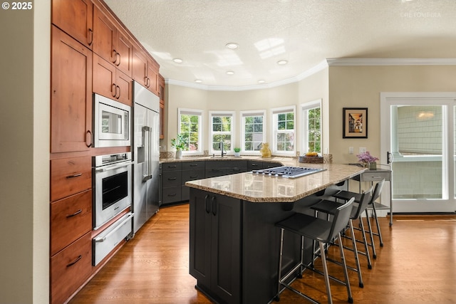 18462 Anduin Ter, Lake Oswego, OR 97034 - kitchen with appliances with stainless steel finishes, a warming drawer, a peninsula, wood finished floors, and a sink