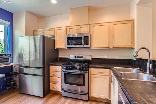 390 NW 116th Ave Unit 103, Portland, OR 97229 - kitchen with appliances with stainless steel finishes, light brown cabinetry, light wood-style floors, and recessed lighting