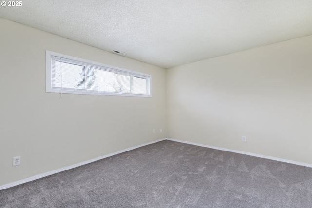 empty room with visible vents, baseboards, carpet, and a textured ceiling
