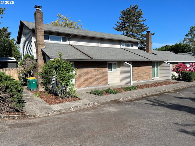 5543 SW Lombard Ave, Beaverton, OR 97005 - view of front of home with a chimney, brick siding, roof with shingles, and fence