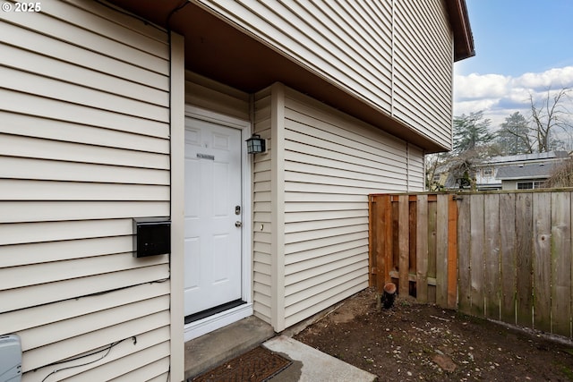 view of exterior entry featuring fence