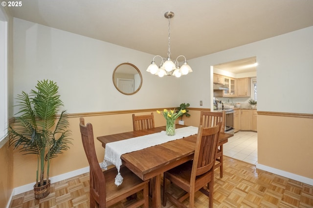 dining area with a chandelier and light parquet floors