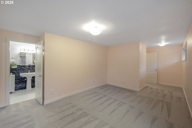 spare room with light colored carpet and sink