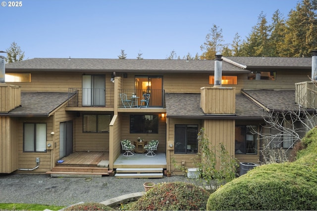 view of front of property with a balcony, central air condition unit, and a deck