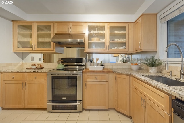 kitchen with light brown cabinets, sink, light stone countertops, light tile patterned flooring, and stainless steel appliances