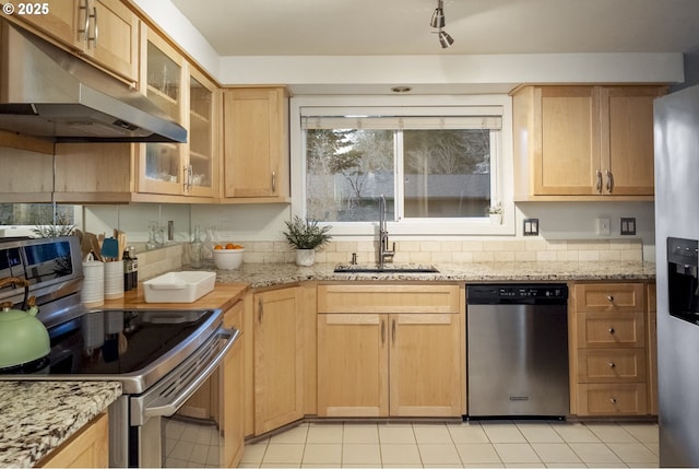 kitchen with light stone counters, light brown cabinets, sink, and stainless steel appliances