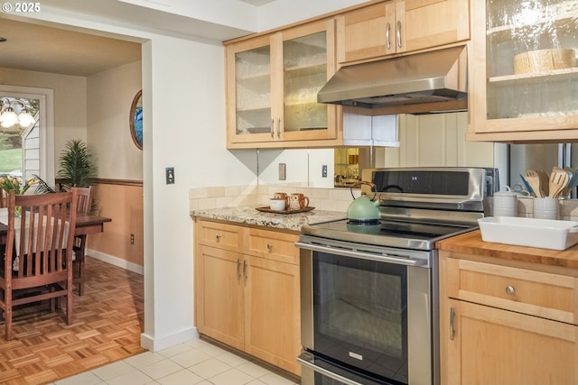 kitchen with stainless steel electric range oven, light brown cabinetry, light tile patterned floors, and light stone countertops