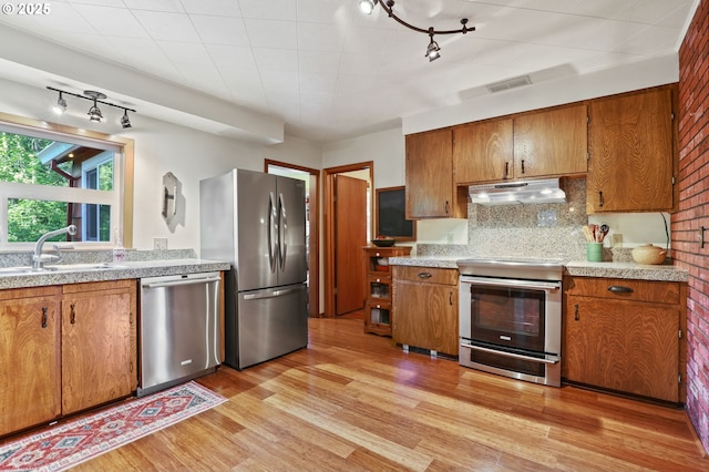 25701 S Morgan Rd, Estacada, OR 97023 - kitchen featuring appliances with stainless steel finishes, under cabinet range hood, brown cabinets, and a sink