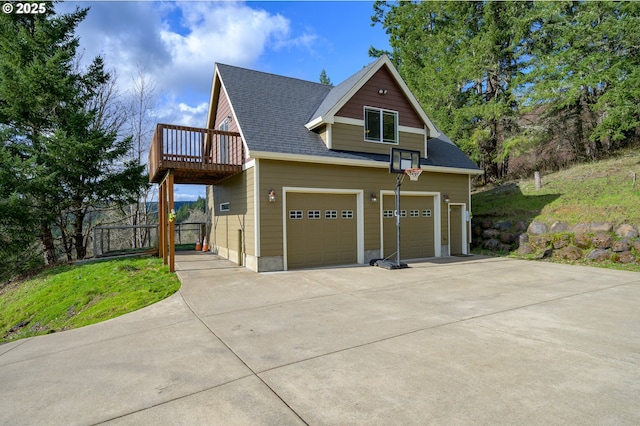 view of front of home featuring a garage and a shingled roof