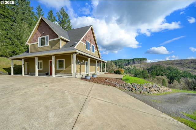 view of property exterior with driveway and a porch