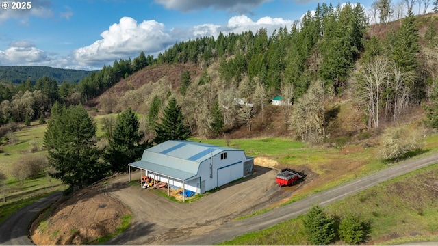 drone / aerial view featuring a wooded view