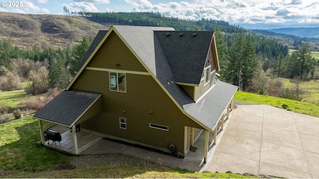 birds eye view of property featuring a forest view and a mountain view