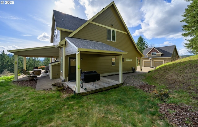 back of house featuring a shingled roof, a patio, and a lawn