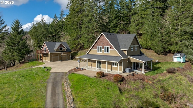 view of front of property with central air condition unit, covered porch, a garage, driveway, and a front lawn